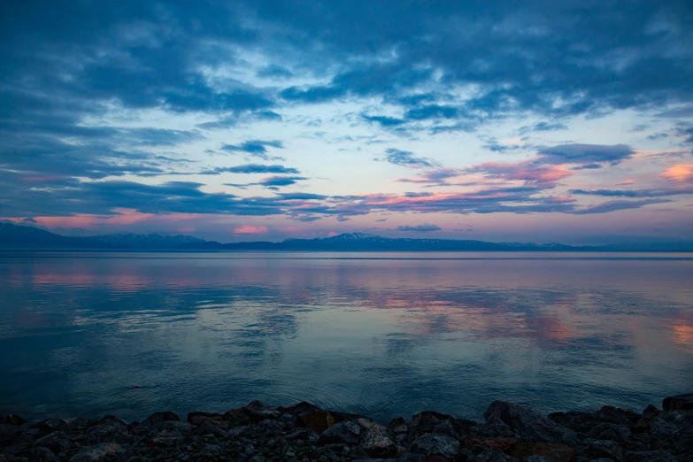 the ocean water has clouds and rocks