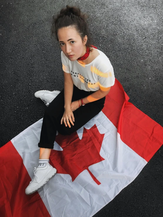 the young woman is sitting on the canada flag