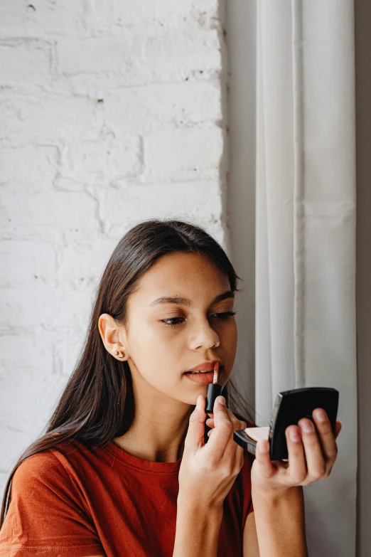 woman with long black hair looking down holding a cell phone