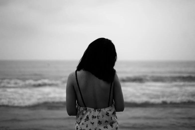 back view of woman standing on the beach