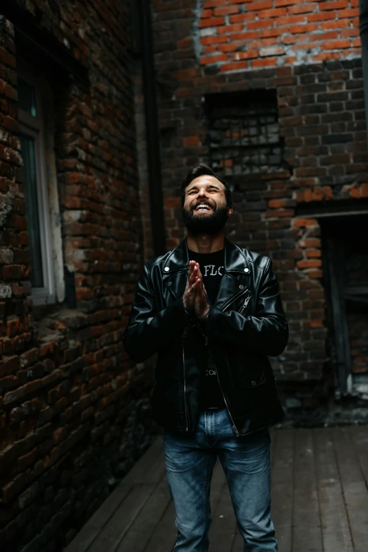 a man standing with his hands folded in front of him