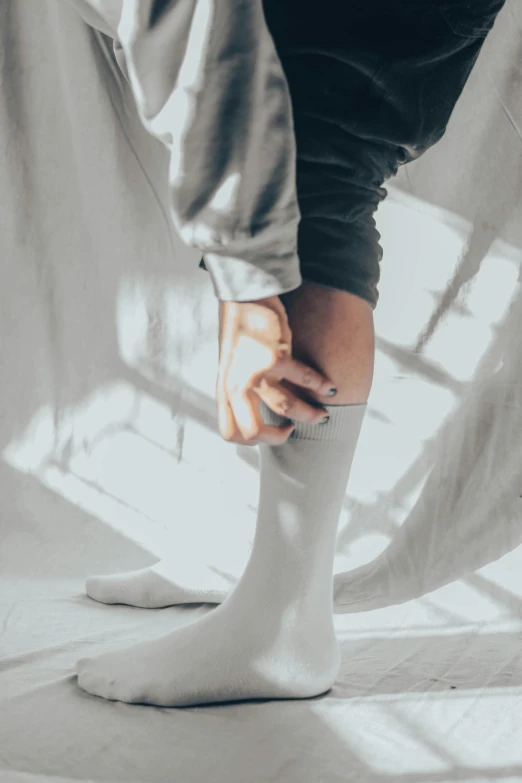 the legs and hands of a person holding a socks