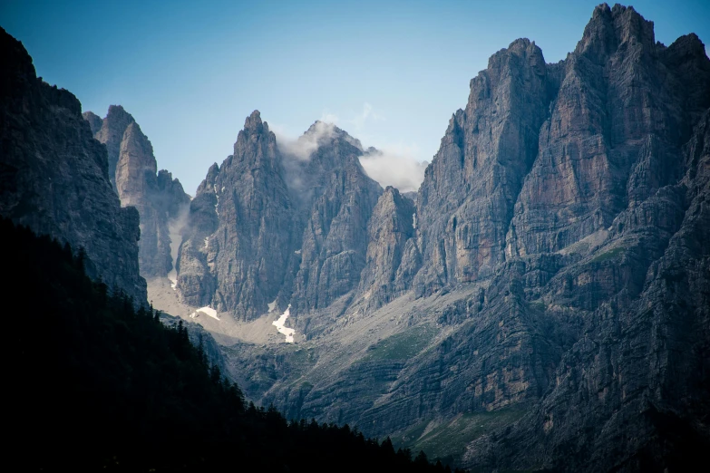 there are mountains covered with mist near a forest