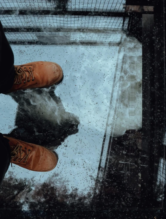 a person wearing orange boots is standing near a mirror