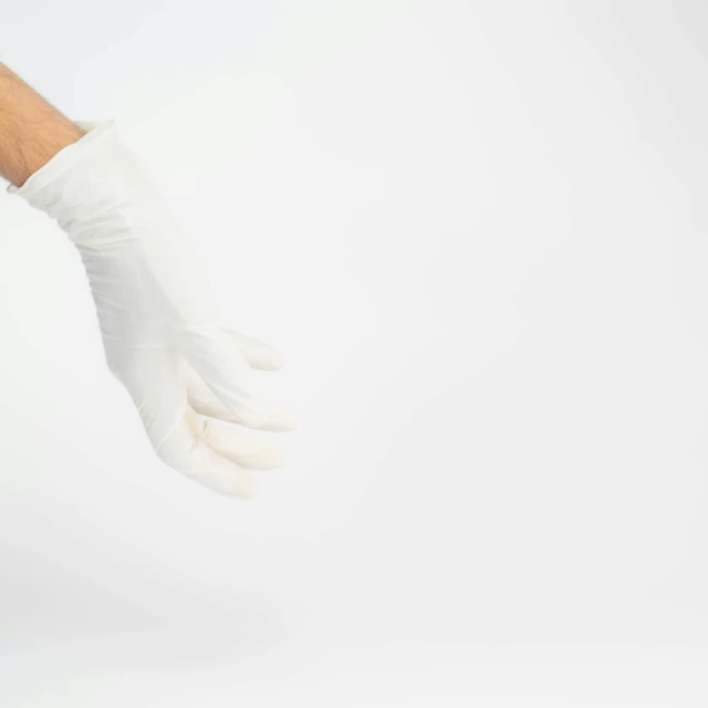 a hand wearing white gloves over white background