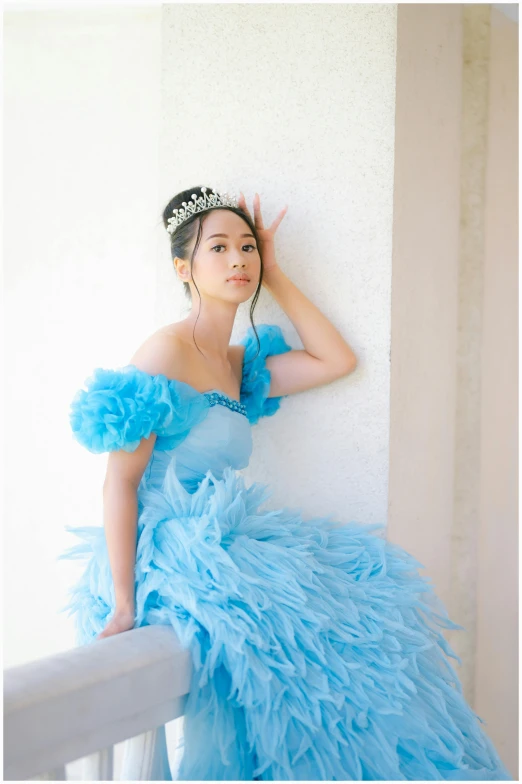 a young woman poses for a po in a blue dress