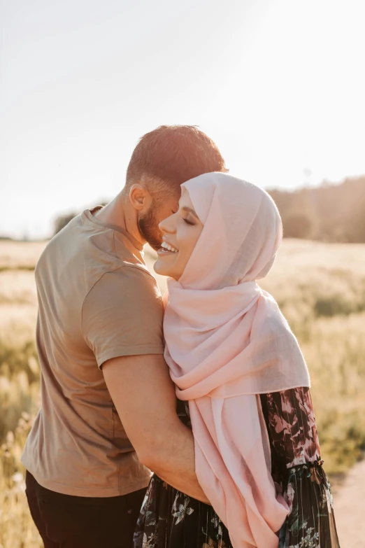 a man and woman wearing a headscarf are hugging