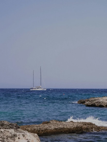 the ocean and the sailboat near the shoreline