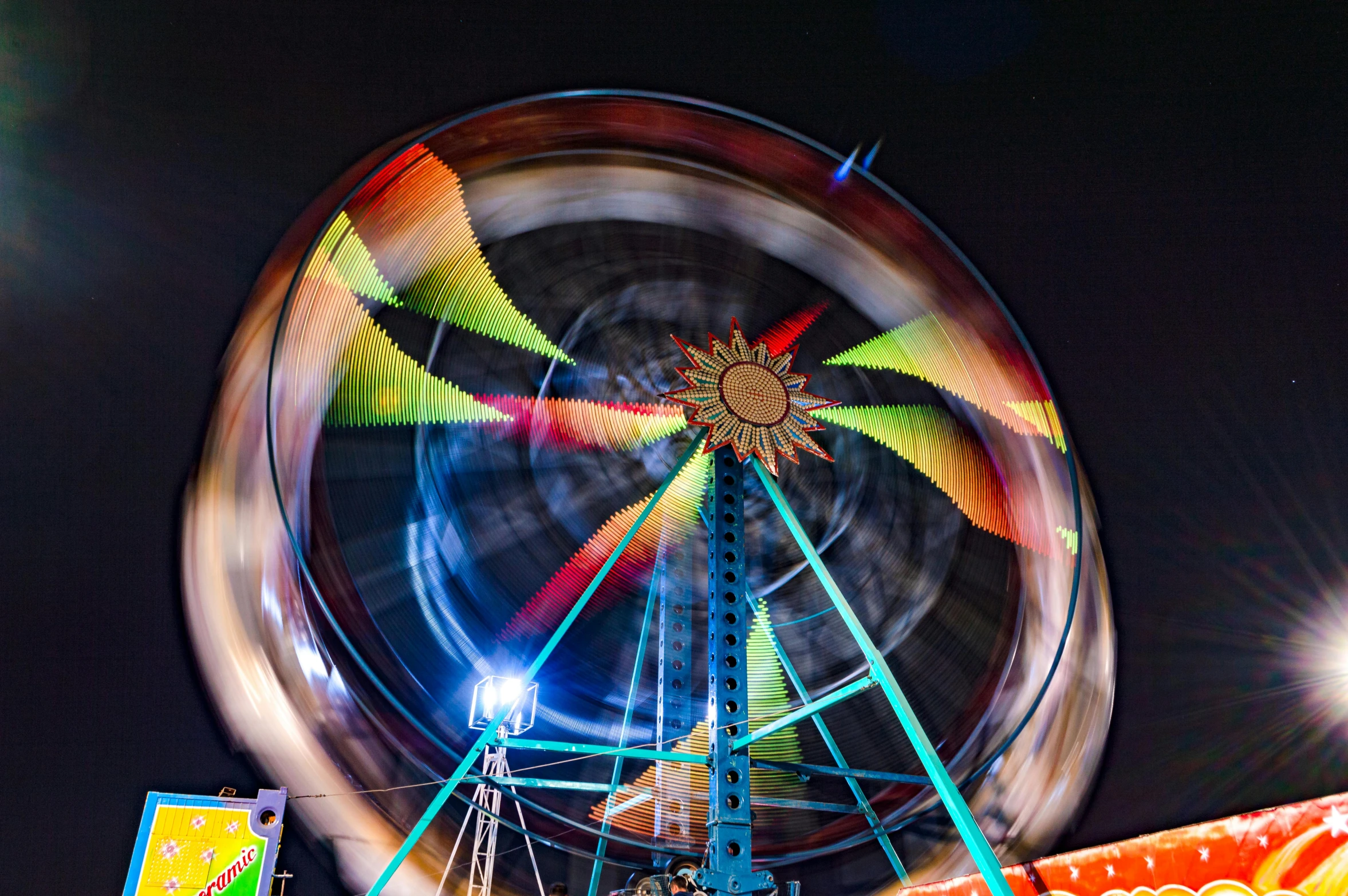 colorful ferris wheel at night with full moon in background