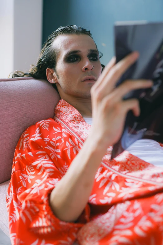 woman wrapped in red holding up her tablet