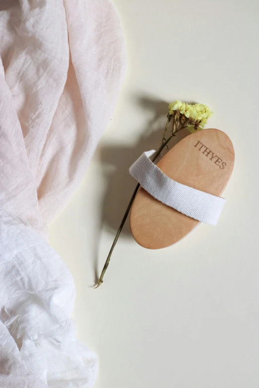 flower with ribbon tied on wooden board with fabric as background