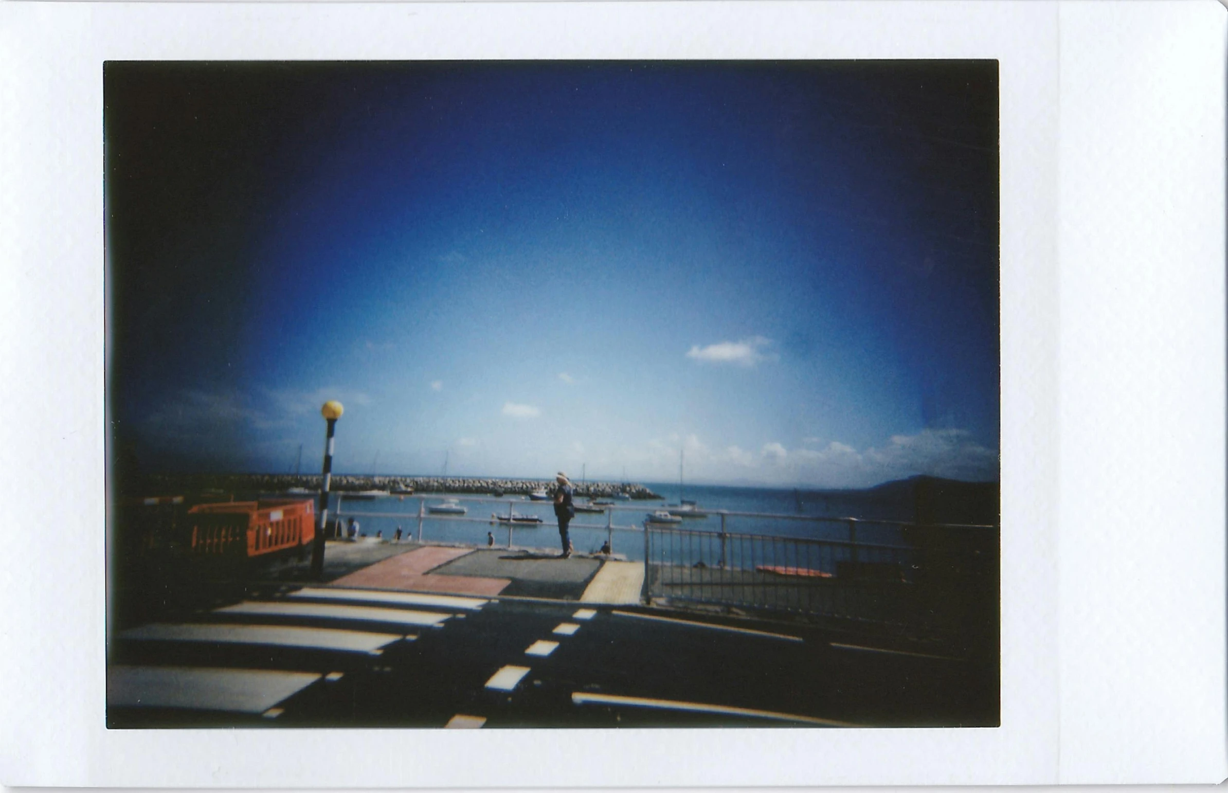 a polaroid po of a person walking on the pier