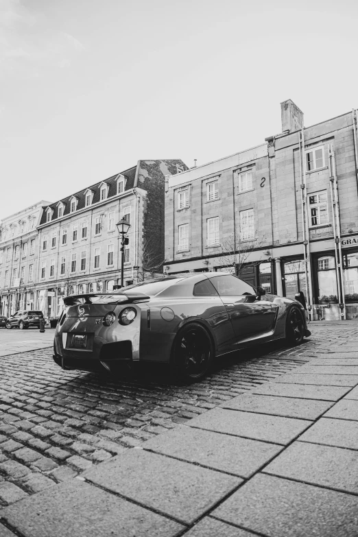 a black and white po of a sports car parked on the side of a road