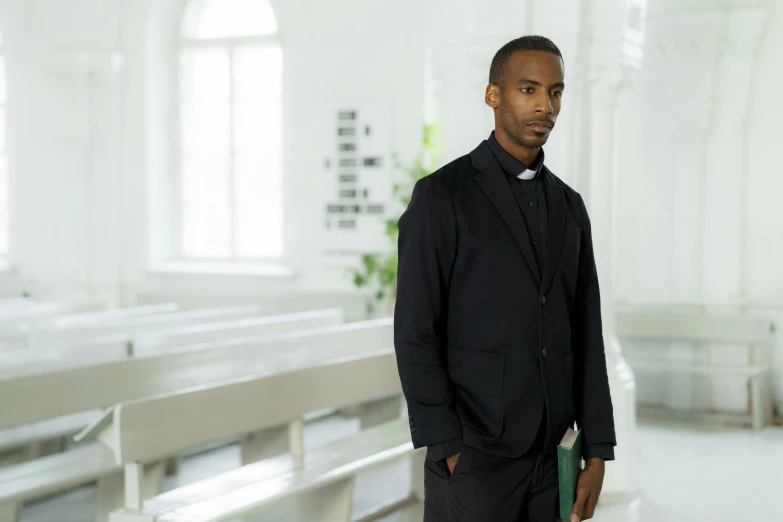 a man in a suit and tie standing next to some pews