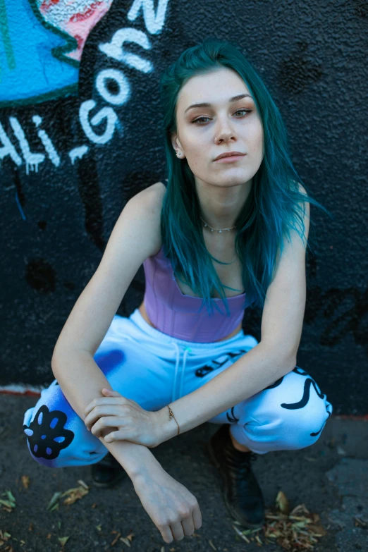 woman with bright green hair sitting on the ground