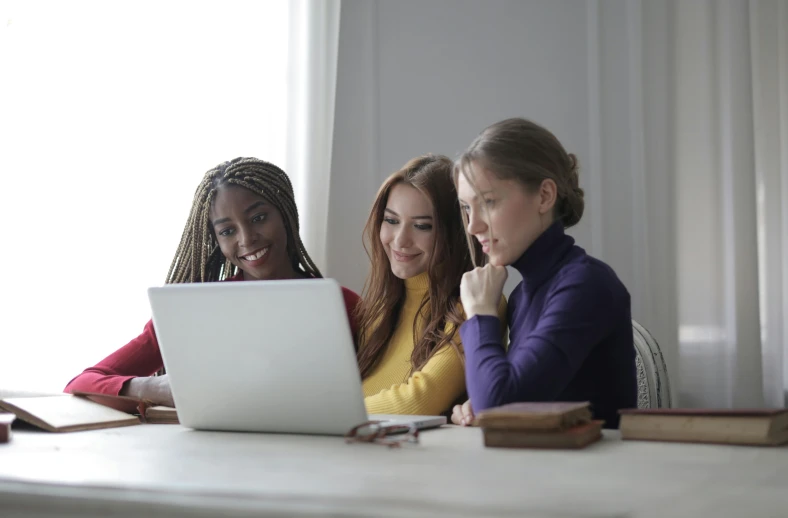 two women and a girl look at a computer screen