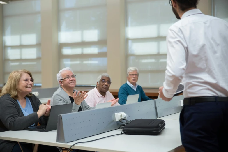 people sitting around a desk smiling at a person