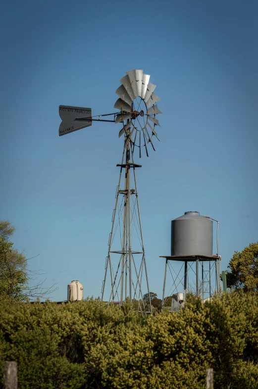 a windmill and water tower on top of a hill