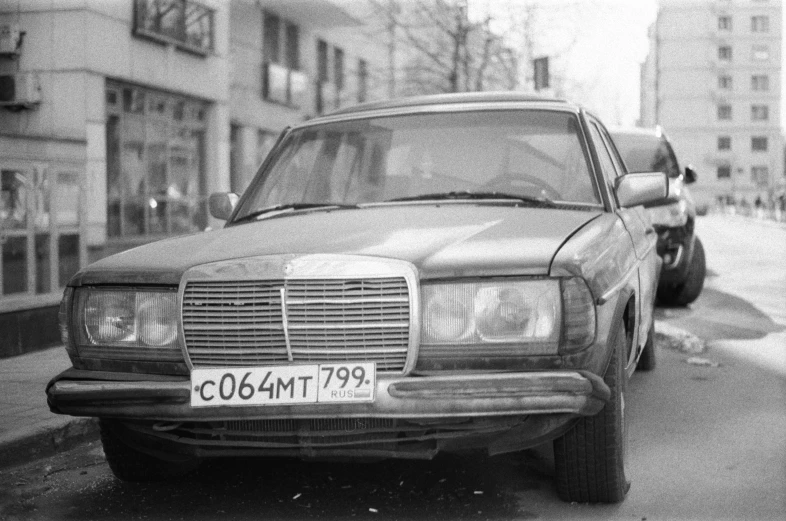 black and white pograph of a mercedes parked in an urban street