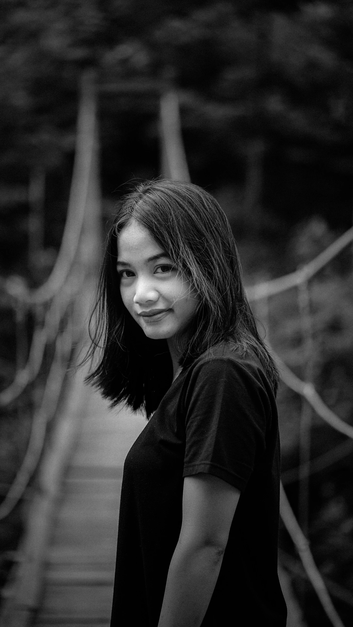 a woman poses for a picture on a bridge