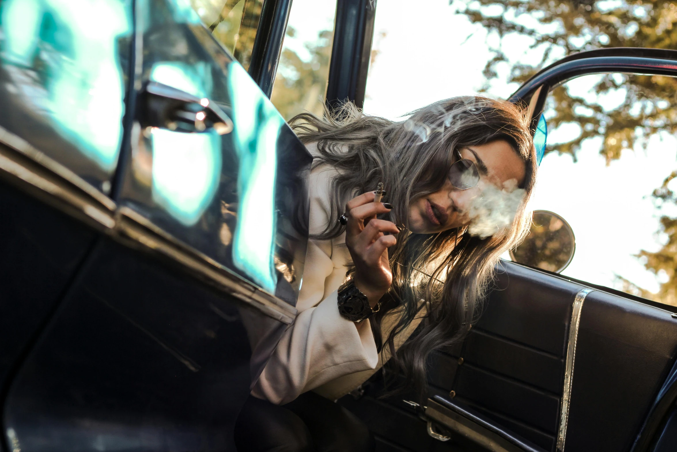 a woman talking on her cell phone behind the door of a car