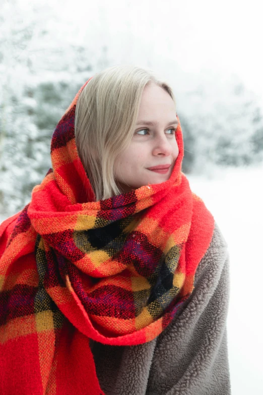 a woman in a plaid scarf smiling for the camera