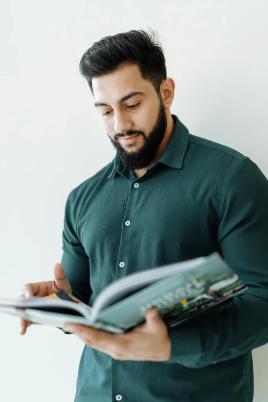 a man looking through the book as he reads it