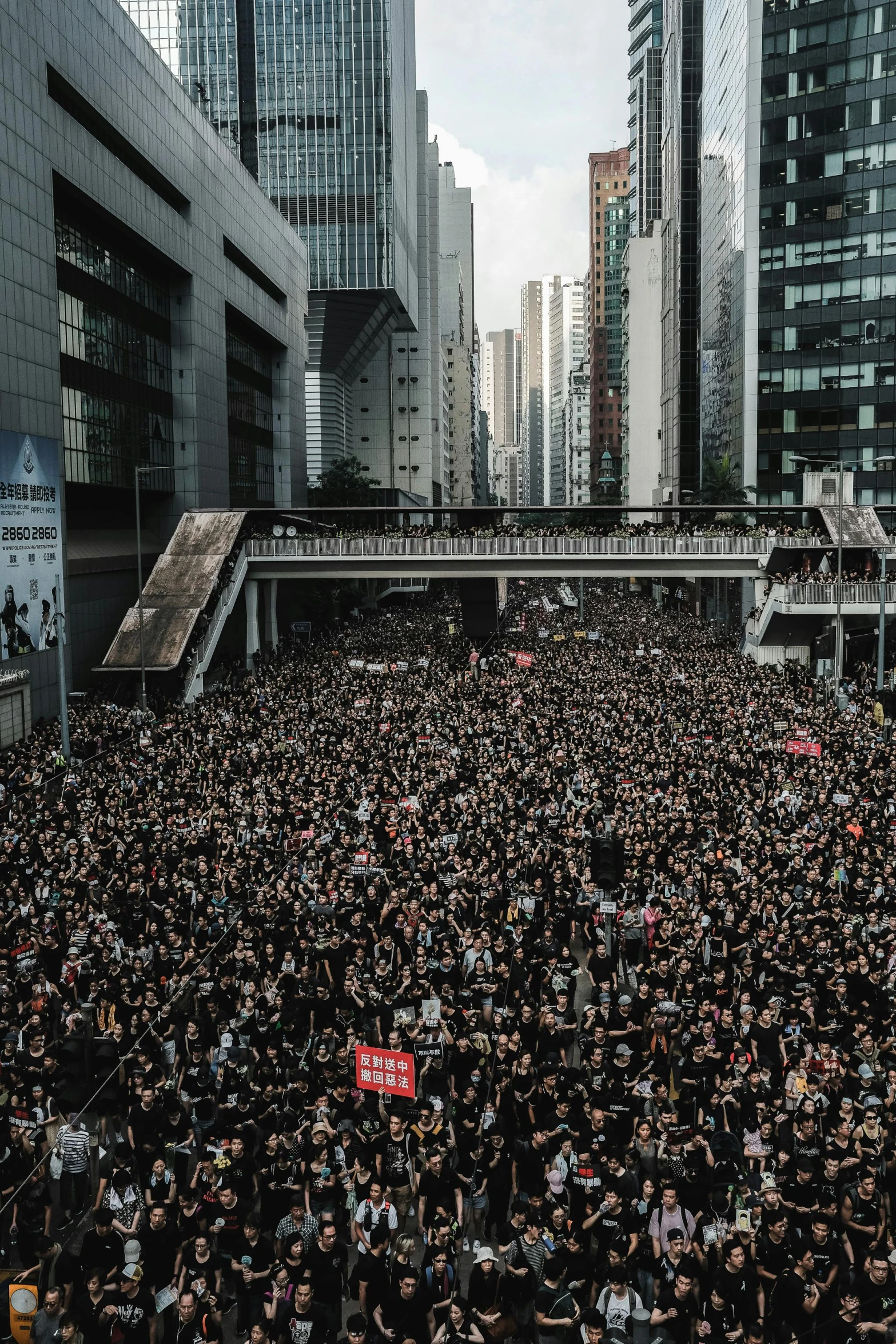 the large crowd is standing in front of a large building