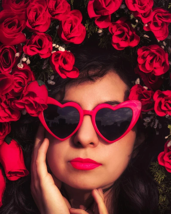 a woman with red glasses with roses surrounding her