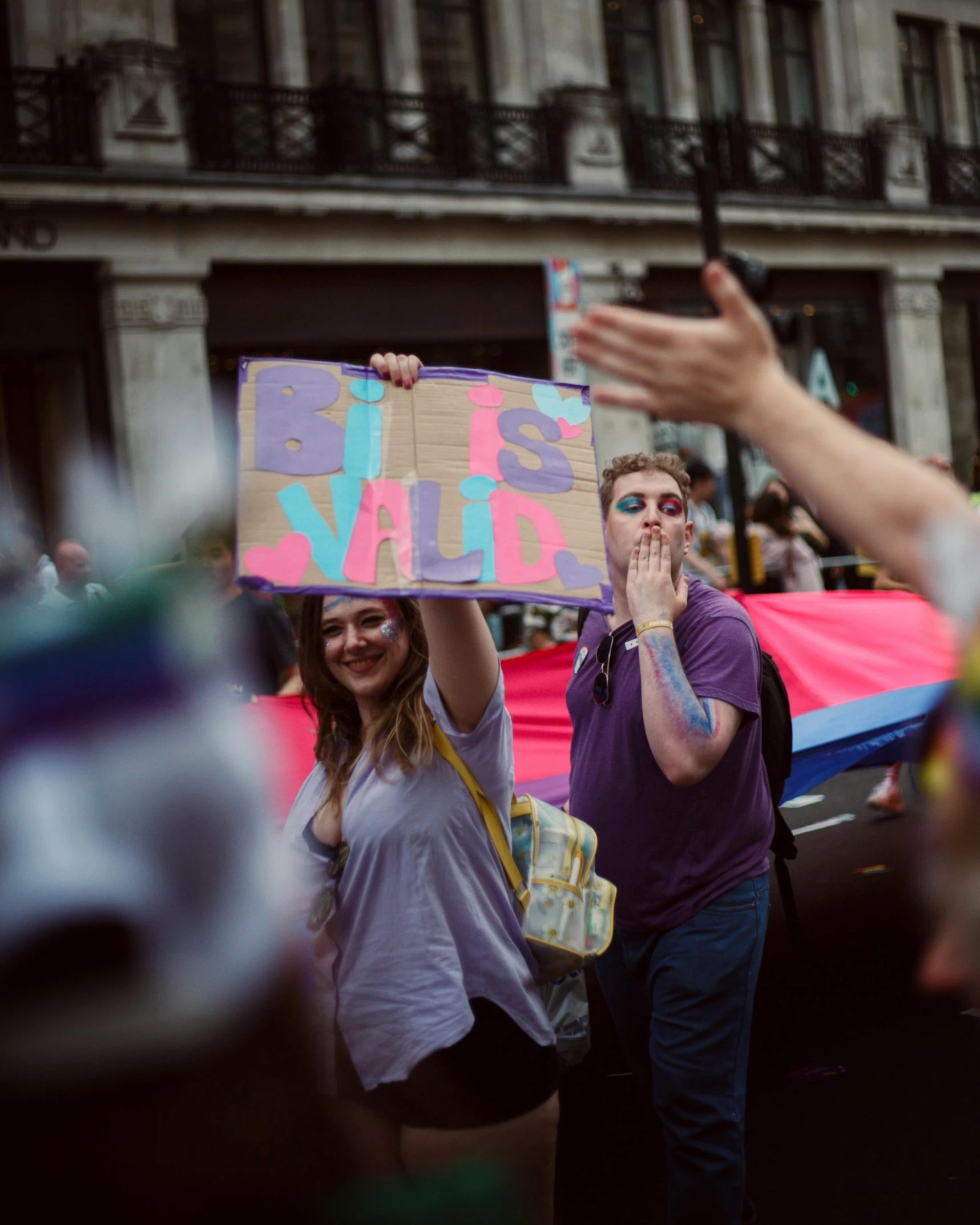 two women standing together and holding a sign