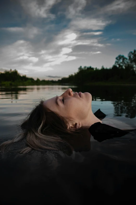 woman laying down in water looking up at sky