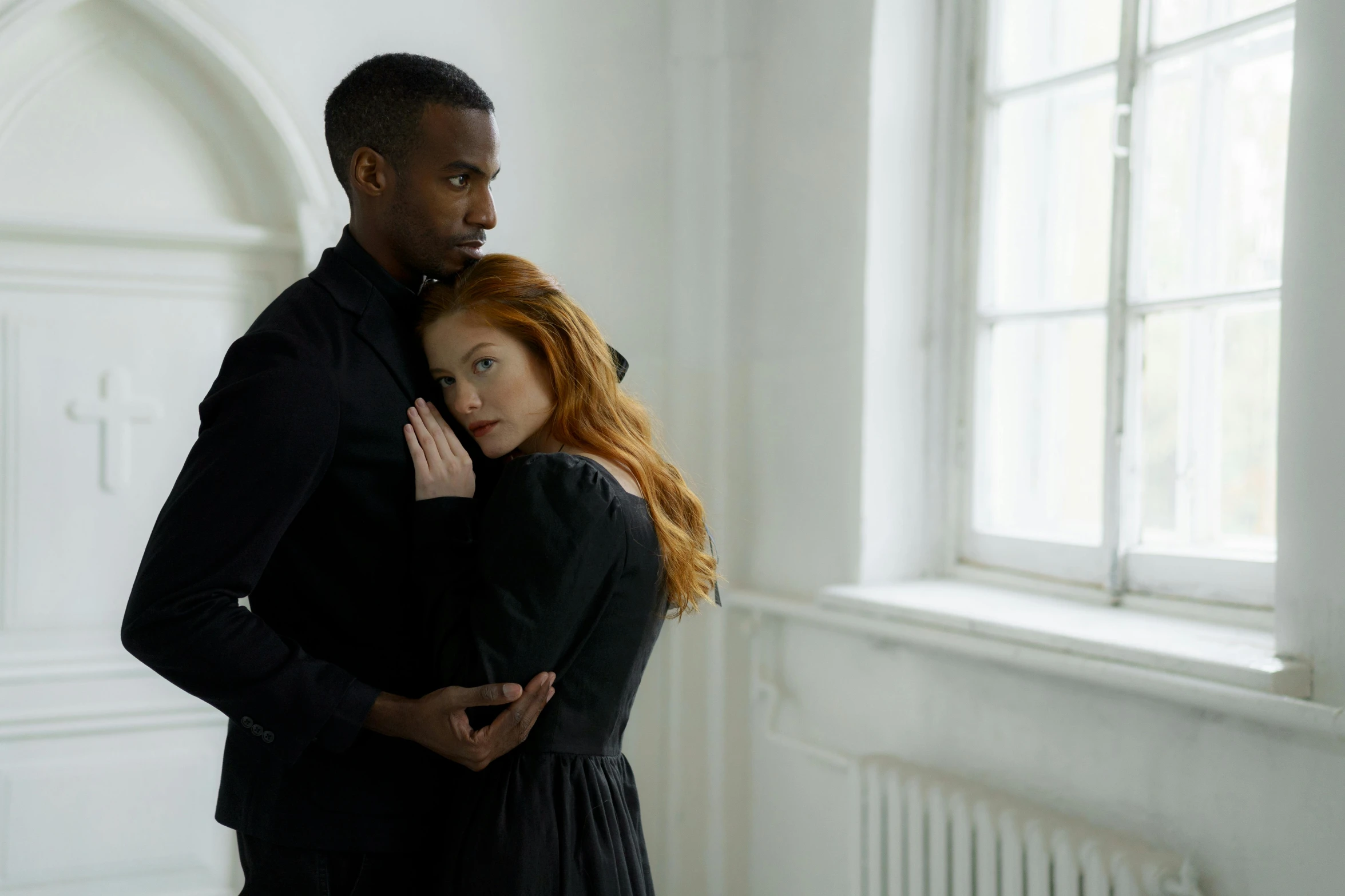 the man and woman stand together in an empty room