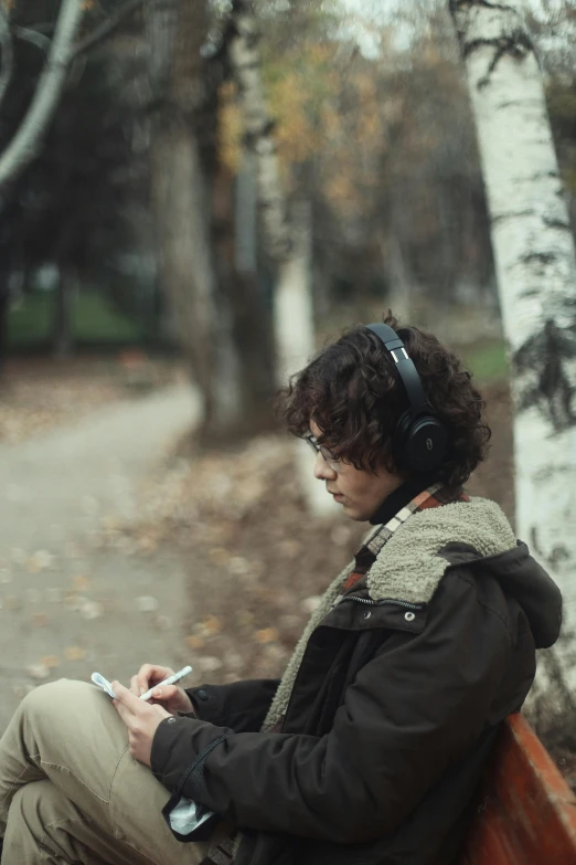 man sitting on a bench in a forest listening to music