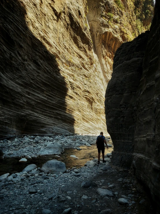 a man with his foot off the ground in the water at the edge of a narrow cliff