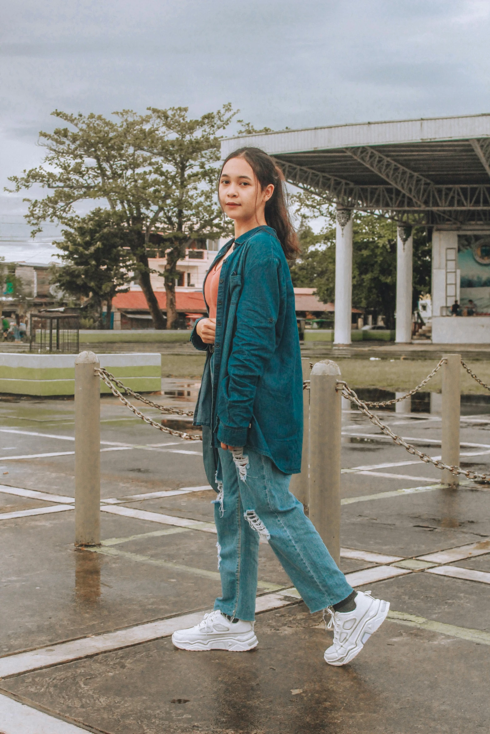 a woman in green coat standing on pavement