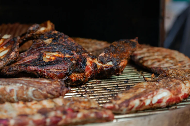 a barbecue grill full of steaks and other food