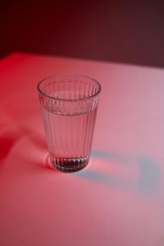 the glass is casting a shadow on a red surface