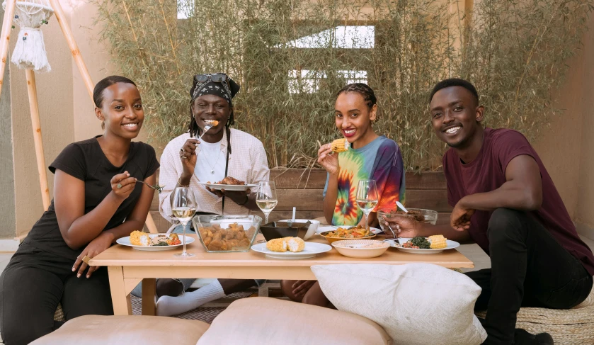 a group of four friends smile while eating