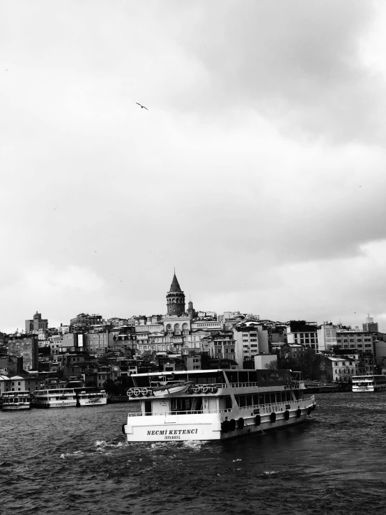 a white boat traveling past tall buildings in the water