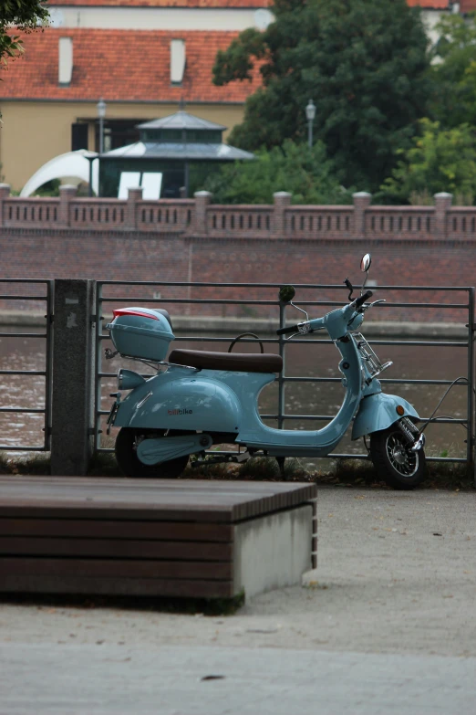 a scooter that is parked by a fence