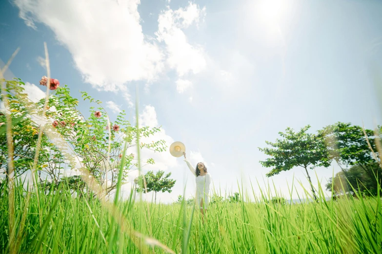 a woman with a fan is in the grass