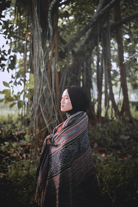 a woman is standing in the middle of the woods