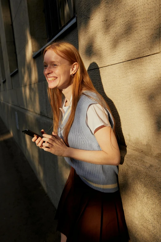 a young lady is posing with her cell phone