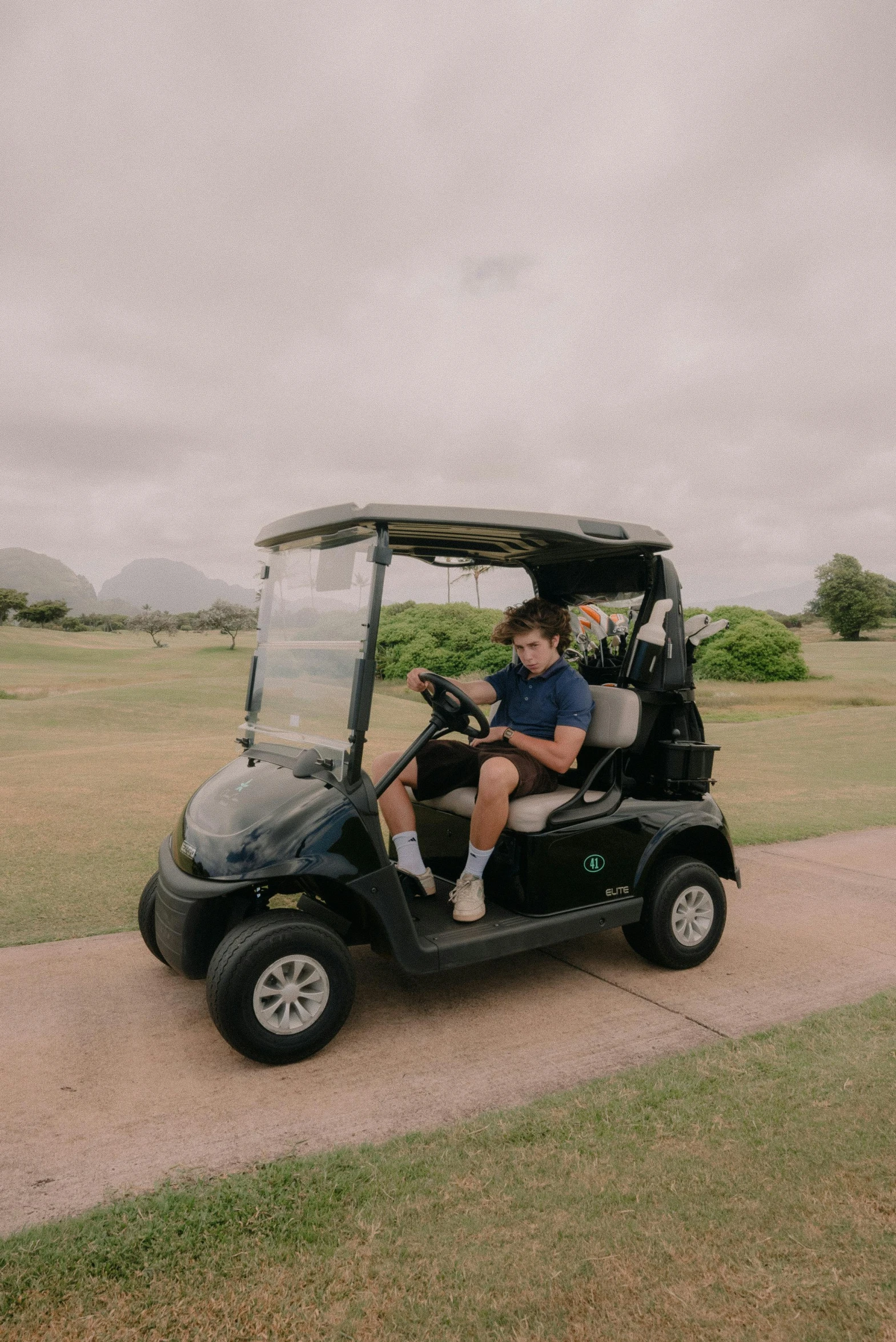 a young person on a golf cart in the street