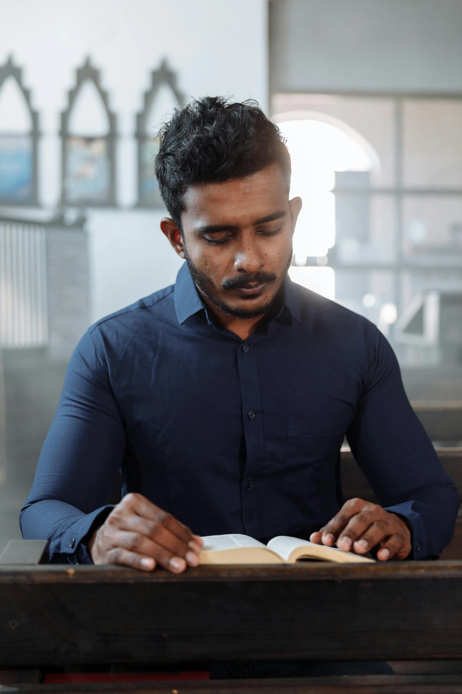 a young man is studying a book in a room