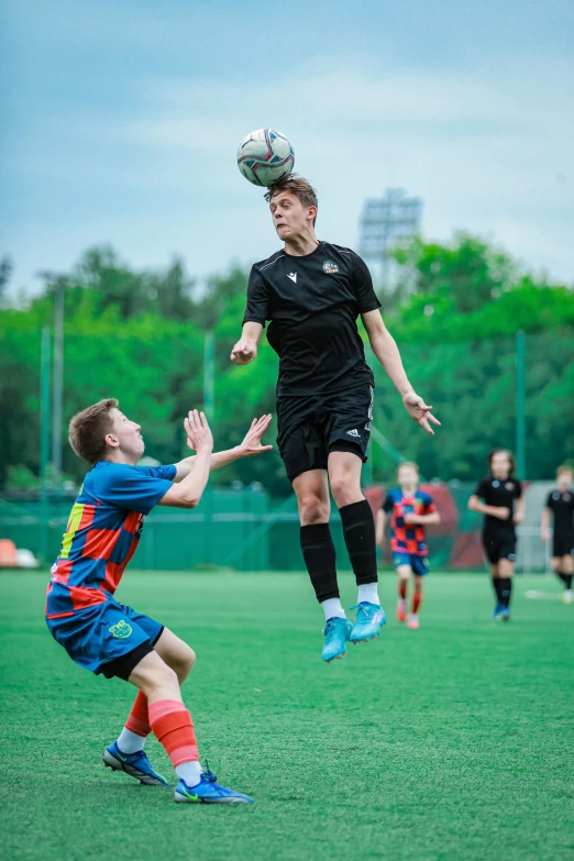 two soccer players colliding to compete for the ball