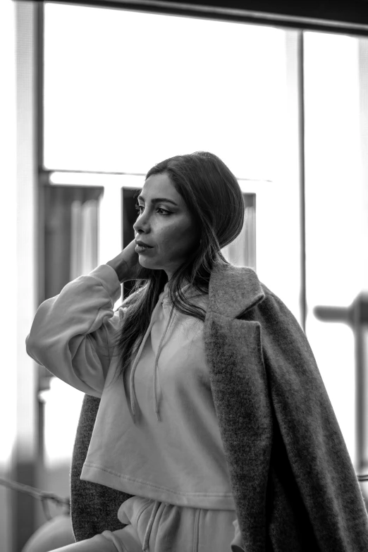 a woman wearing a hat and jacket walking down the street