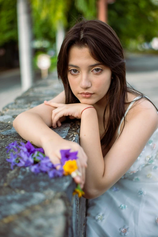 a woman that is laying down near flowers