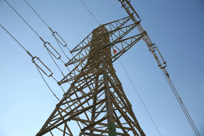 the tall metal tower has many power lines