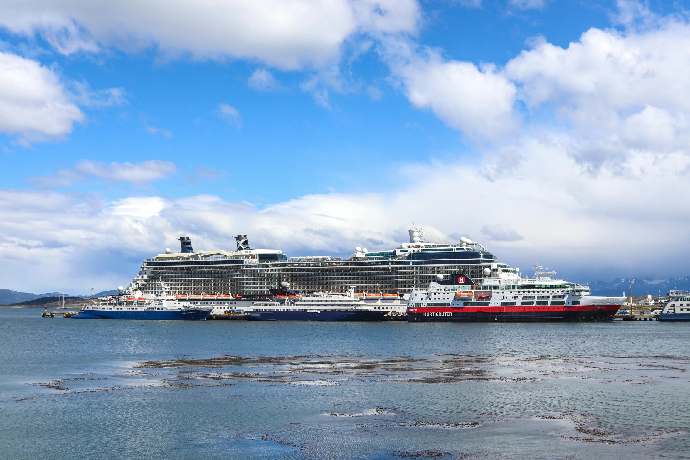 a cruise ship sailing next to another smaller ship